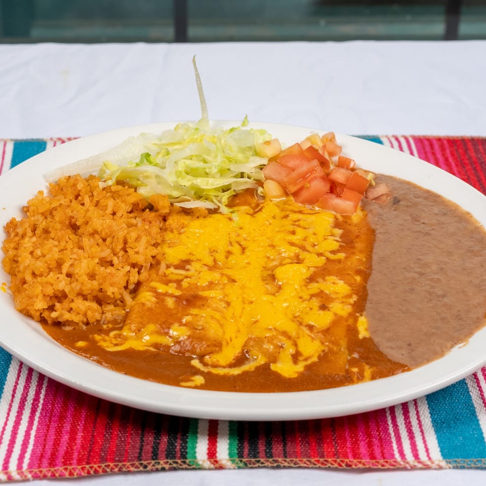 Enchiladas plate on a colorful striped tablecloth.