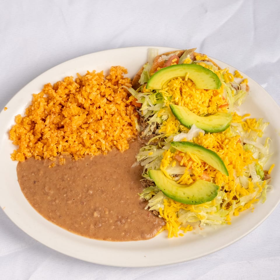 Chalupas topped with lettuce, cheese and avocado.