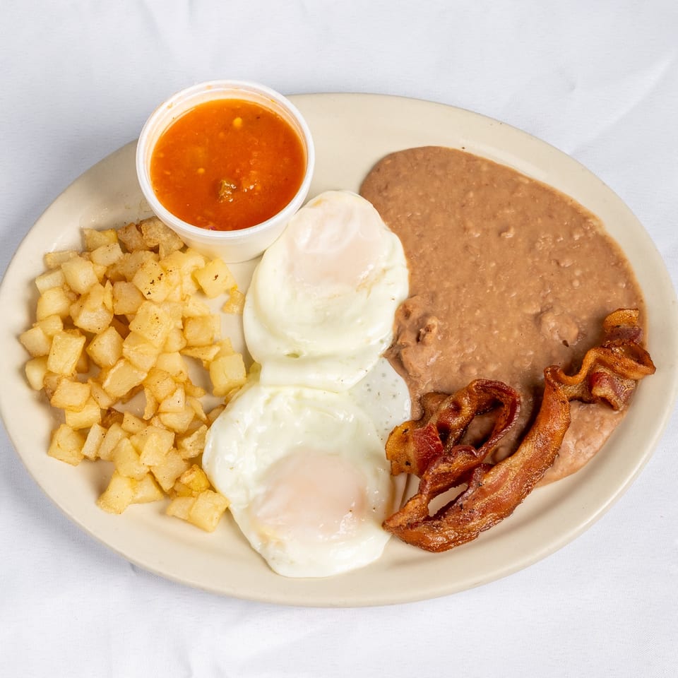 Breakfast plate with eggs, bacon, potatoes, beans and salsa.